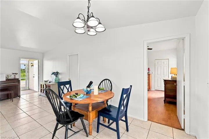 Dining area featuring a classic five-light chandelier and tile flooring