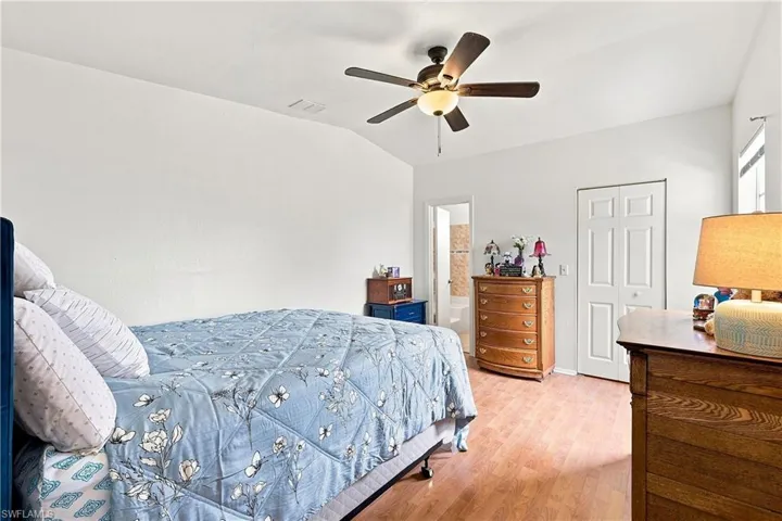 Bedroom featuring wood-finish flooring, vaulted ceiling, and a ceiling fan with integrated lighting