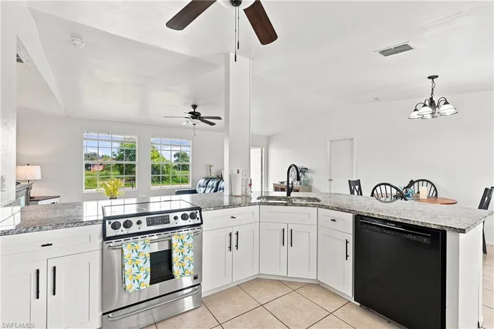 Kitchen featuring white cabinetry, granite countertops, and a breakfast bar