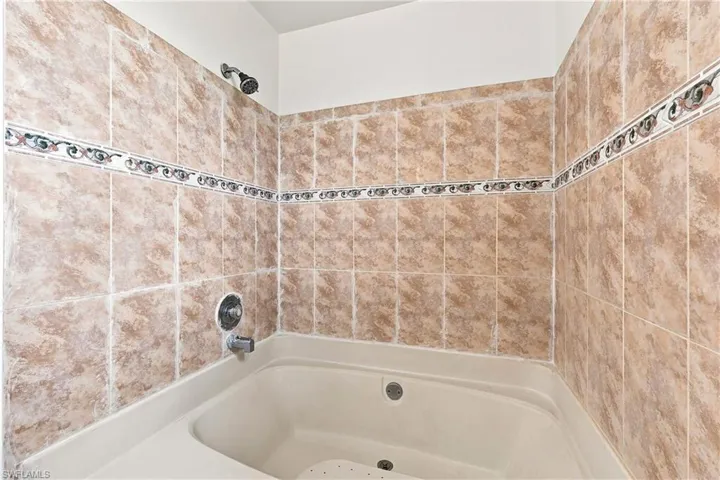 Built-in corner bathtub with a tiled surround