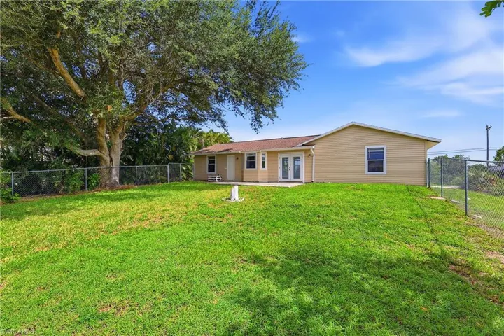 Expansive green lawn with a large mature tree providing shade