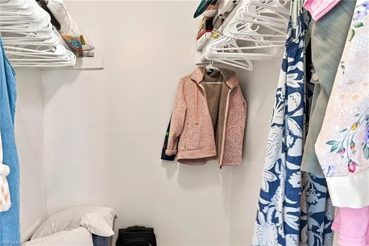 Integrated closet shelving with white walls and a corner storage area