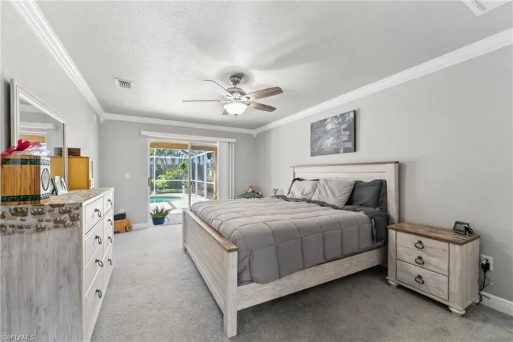 Bedroom featuring access to exterior, ornamental molding, light colored carpet, a textured ceiling, and ceiling fan