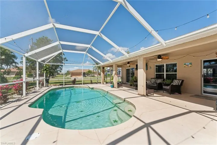 Outdoor pool featuring a patio, a ceiling fan, an outdoor hangout area, and glass enclosure