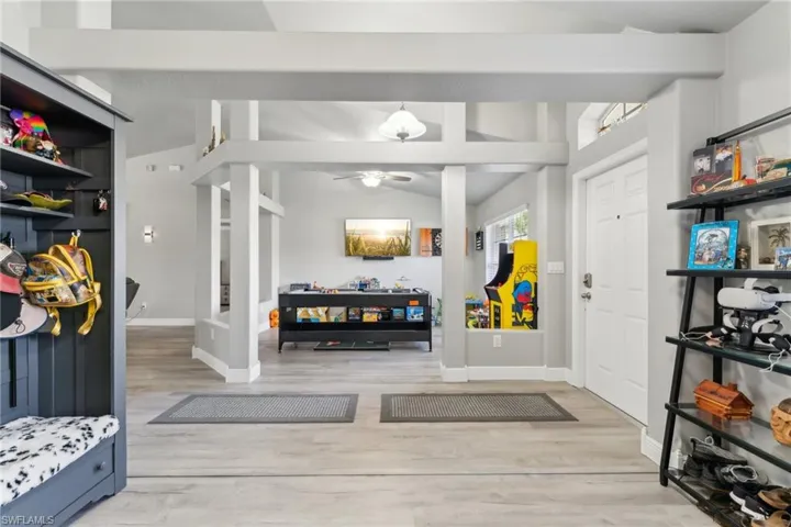 Foyer with lofted ceiling, wood finished floors, baseboards, and a ceiling fan