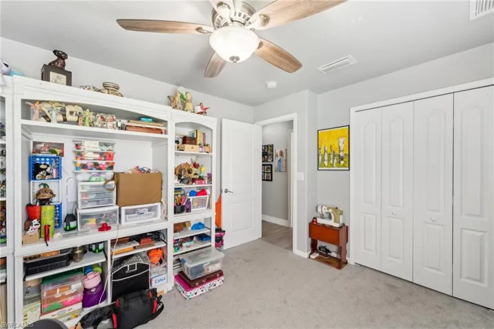 Recreation room with carpet flooring, ceiling fan, and baseboards