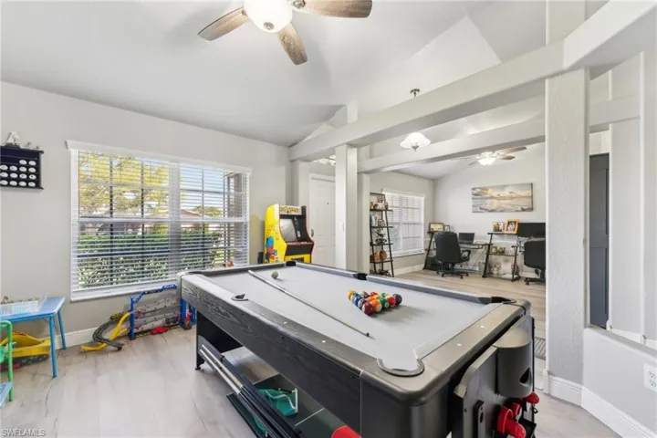Rec room featuring a ceiling fan, vaulted ceiling, pool table, wood finished floors, and baseboards