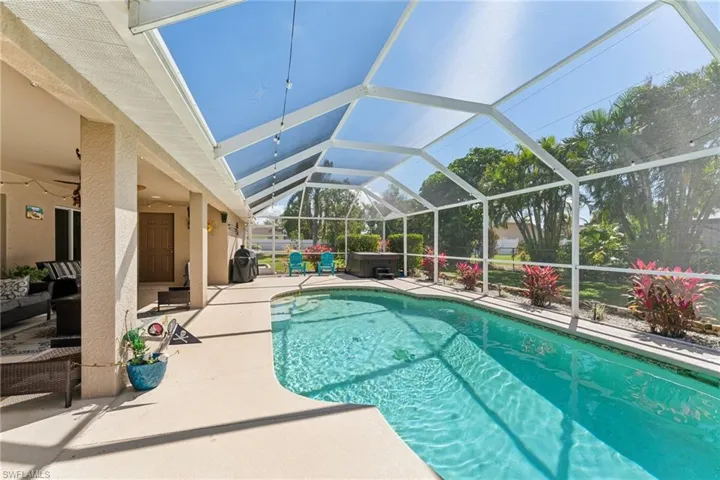 Outdoor pool with a patio, a hot tub, a lanai, and an outdoor living space