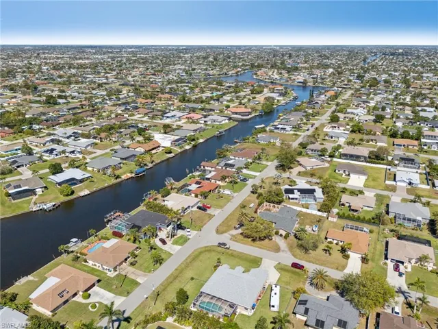 Aerial view of property and surrounding area featuring nearby suburban area and a large body of water