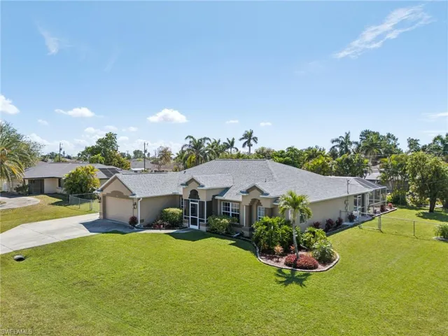 Ranch-style home featuring driveway, a garage, and stucco siding