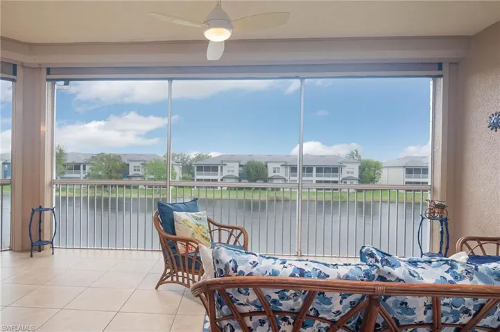 Sunroom / solarium with ceiling fan and a water view