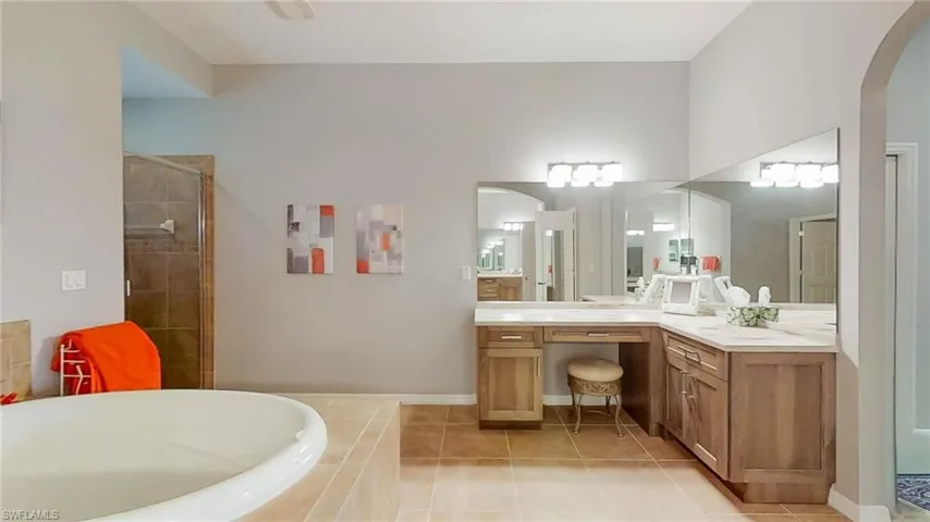 Bathroom featuring tile patterned flooring, vanity, and shower with separate bathtub