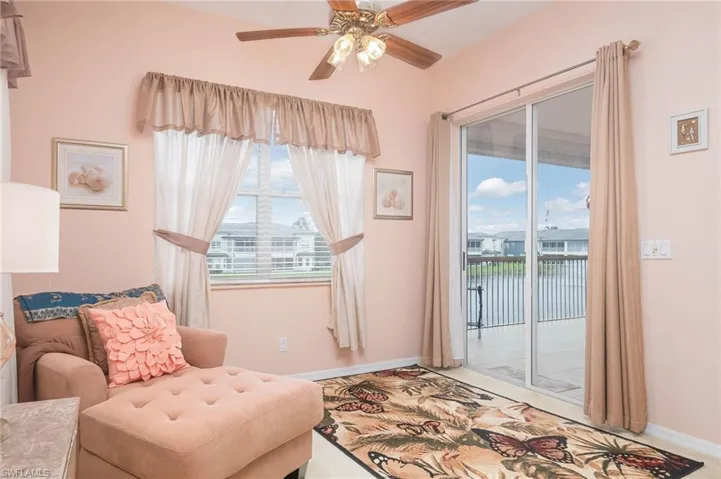Living area with carpet flooring, ceiling fan, and a water view