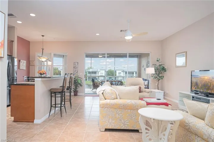 Living room featuring light tile patterned floors and ceiling fan