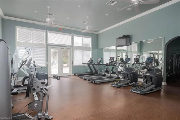Workout area with ceiling fan, ornamental molding, and french doors