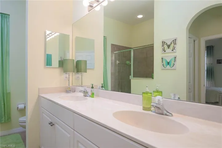 Bathroom featuring vanity, toilet, and an enclosed shower