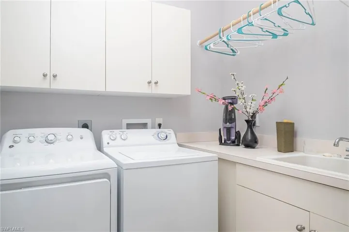 Washroom featuring cabinets, separate washer and dryer, and sink