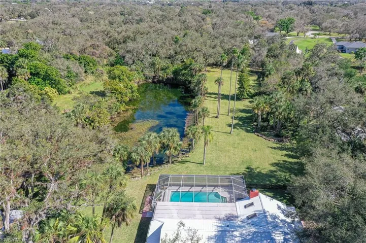 Drone / aerial view of a large pond and a pool area