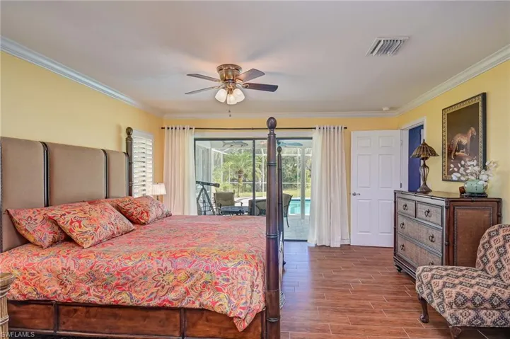Bedroom featuring tiled floors, crown molding, plantation shutters and access to outside