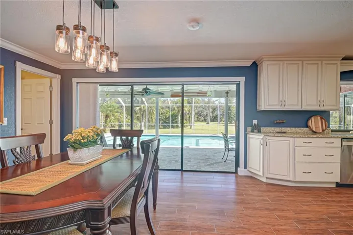 Dining room with a textured ceiling, wood tiled floors, ornamental molding, healthy amount of natural light, and a ceiling fan