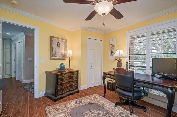 Office space featuring crown molding, wood look tiled floors, and a ceiling fan