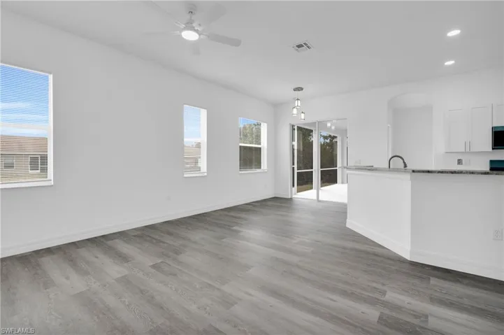 Unfurnished dining area featuring a ceiling fan, recessed lighting, light wood-style floors, and arched walkways