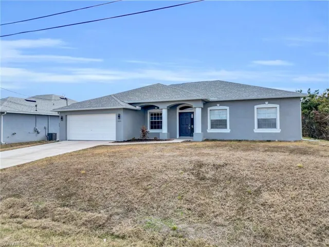Ranch-style house featuring stucco siding, a shingled roof, concrete driveway, an attached garage, and a front yard