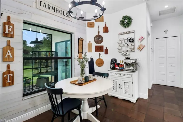 Dining space with dark tile patterned floors and a notable chandelier