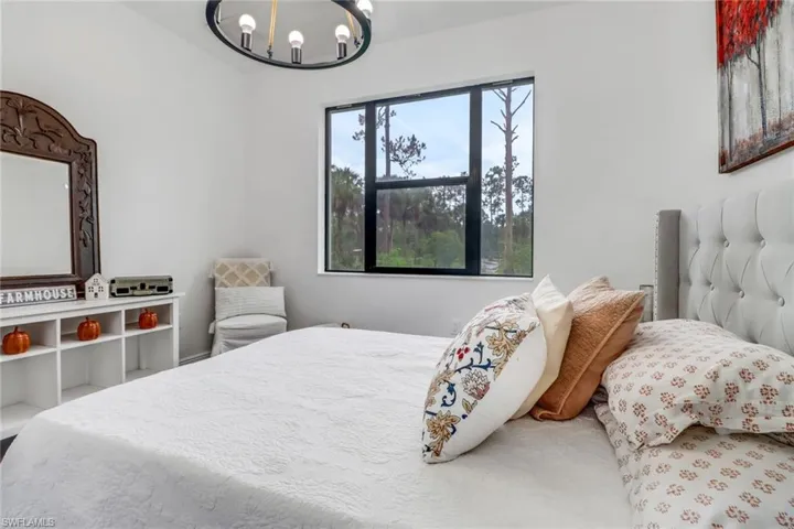 Bedroom with a notable chandelier and multiple windows