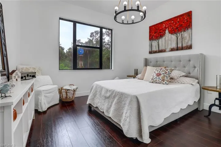 Bedroom featuring dark hardwood / wood-style floors and an inviting chandelier