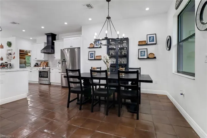 Dining room with dark tile patterned floors and a notable chandelier