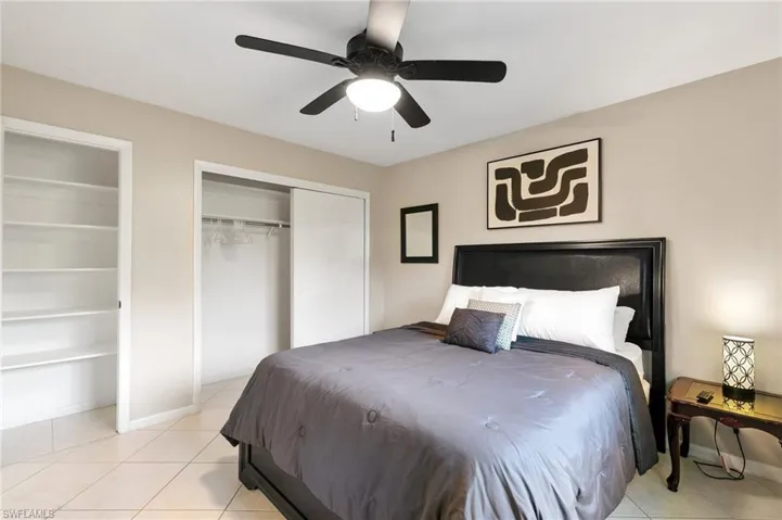 Bedroom featuring two closets, light tile patterned flooring, and ceiling fan