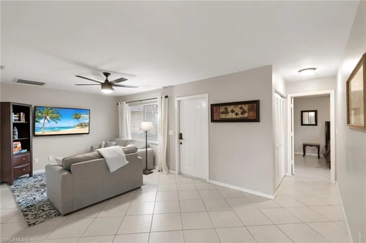Living room with light tile patterned flooring and a ceiling fan