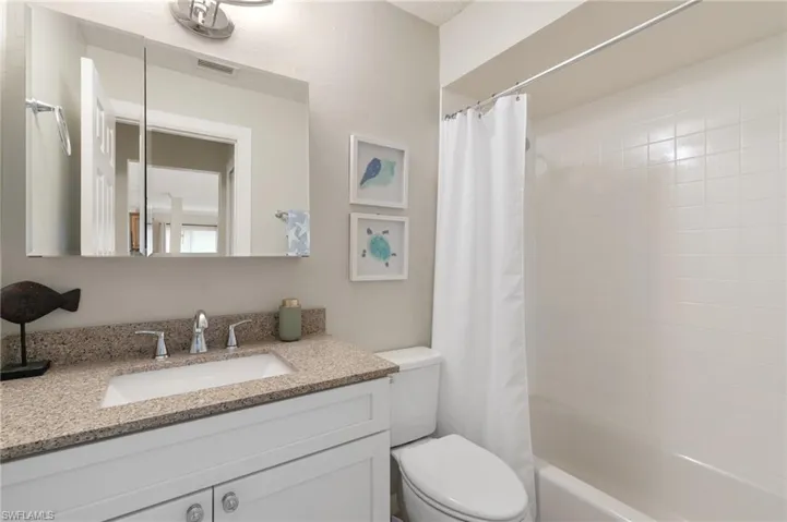 Full bath with shower / tub combo with curtain and vanity