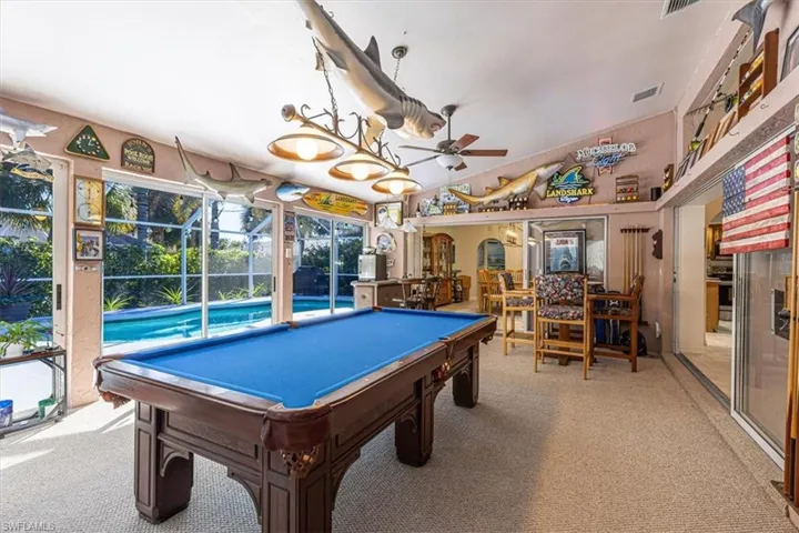 Playroom featuring light carpet, a ceiling fan, arched walkways, pool table, and lofted ceiling
