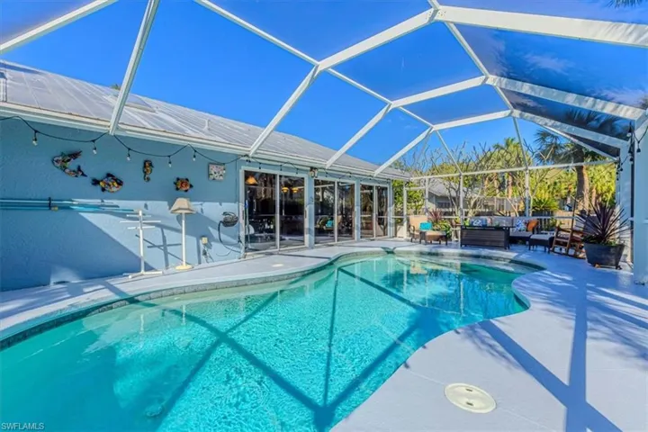 Outdoor pool featuring a sunroom, a patio, a lanai, and outdoor lounge area