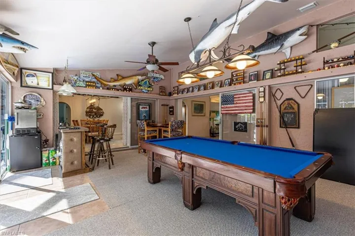 Playroom with a ceiling fan, pool table, arched walkways, and carpet floors