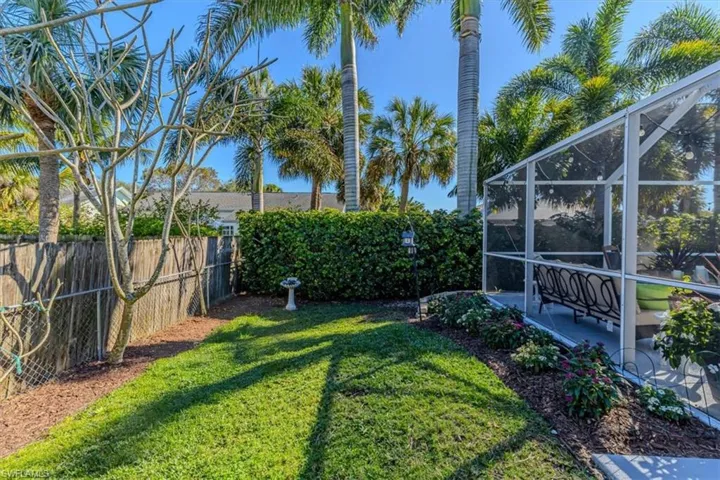 Fenced backyard with a lanai and a sunroom
