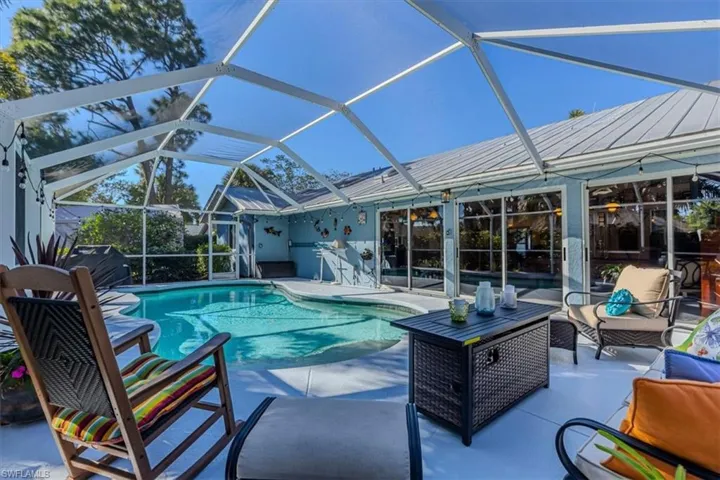 Swimming pool with a sunroom, a lanai, a patio area, and an outdoor living space