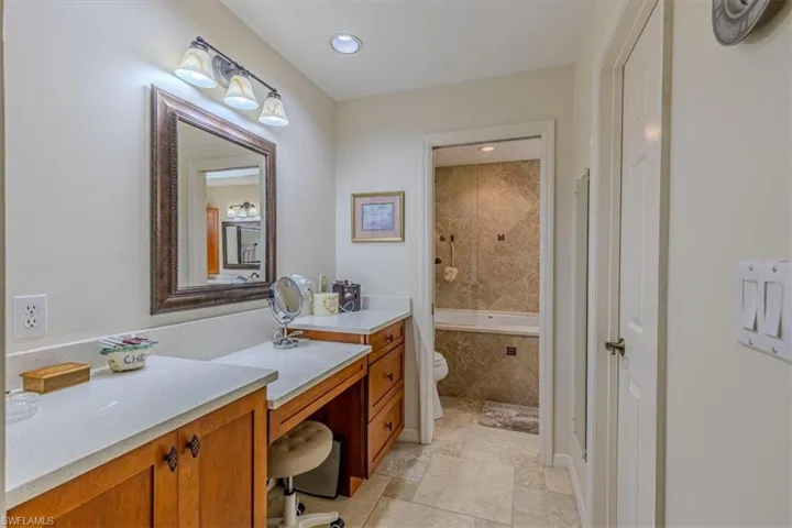 Bathroom with vanity, tiled shower / bath, recessed lighting, and light stone finish floors