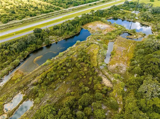 Aerial view of a nearby body of water and a tree filled landscape