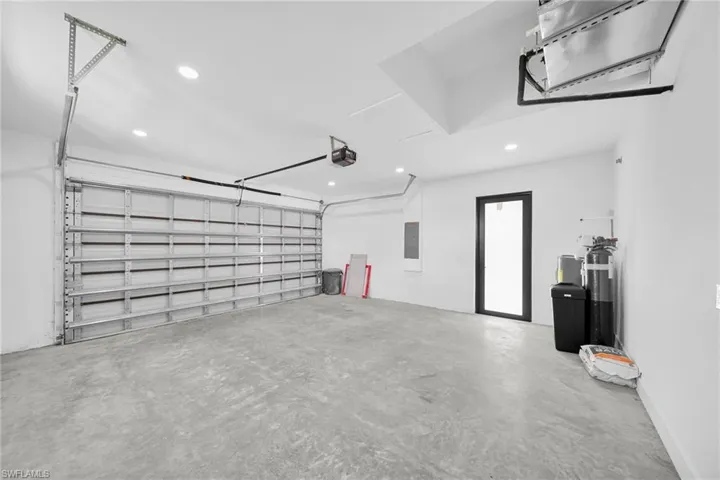 Garage featuring recessed lighting, electric panel, and a garage door opener