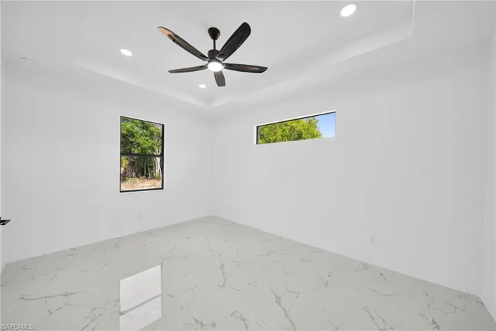 Unfurnished room featuring recessed lighting, a raised ceiling, and a ceiling fan