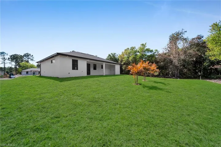View of green lawn with a patio area
