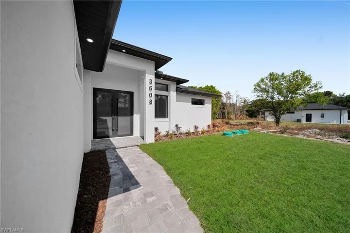 View of green lawn with french doors