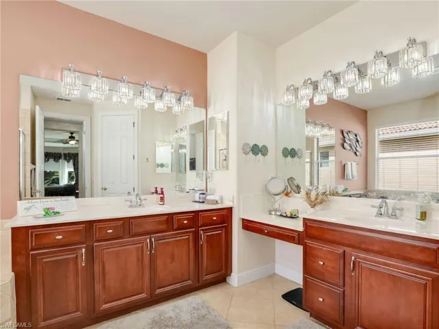 Bathroom with ceiling fan, tile patterned floors, and vanity