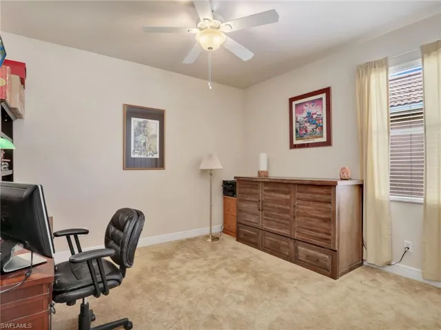 Carpeted home office with ceiling fan