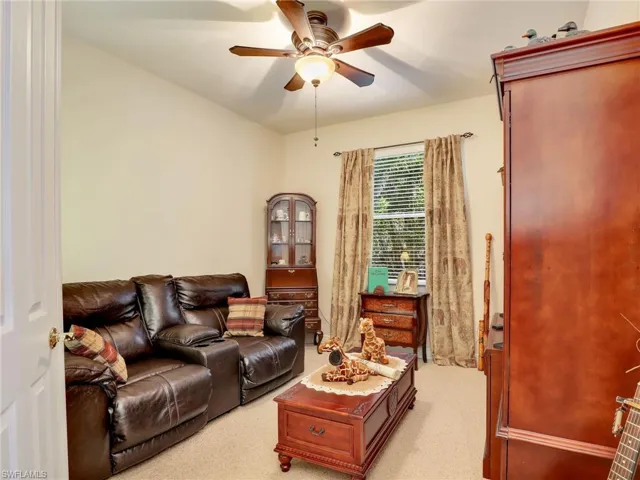Carpeted living room with ceiling fan