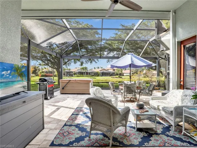 View of patio / terrace with ceiling fan, grilling area, a hot tub, and glass enclosure