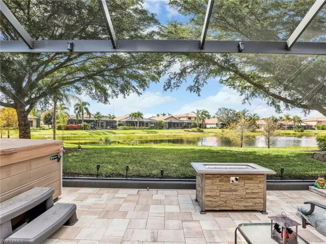 View of patio featuring a water view and glass enclosure